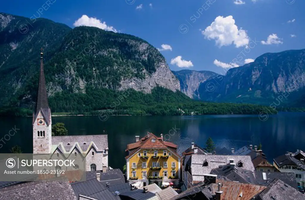 Austria, Oberosterreich, Hallstatt, 'View Over Tiled Village Rooftops, Hotel And Church With Lake And Mountains Behind.'