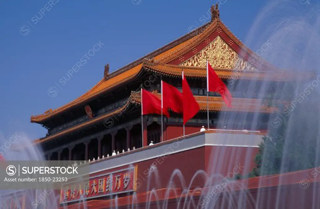 China, Beijing, 'Fountains And Entrance Gateway To The Forbidden City With Red Flags And Red And Gold Decorated, Tile Pavilion-Style Rooftop .  '