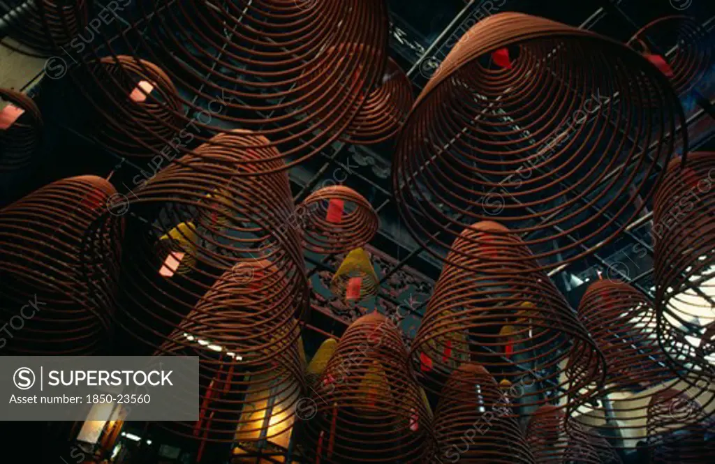 Hong Kong, Central District, Man Mo Temple, Spiral Cones Of Incense Hanging From Roof Of The Man Mo Or Warlord Temple.  The Warlord God Is Kwan Tai And Is Patron Of Both Police And Gangsters.  A Historical Figure From The Three Kingdoms Period (Ad 220-265) He Was Deified As A Taoist Symbol Of Integrity And Loyalty.  The Temple Is Dedicated Jointly To Kwan Tai And The God Of Literature.