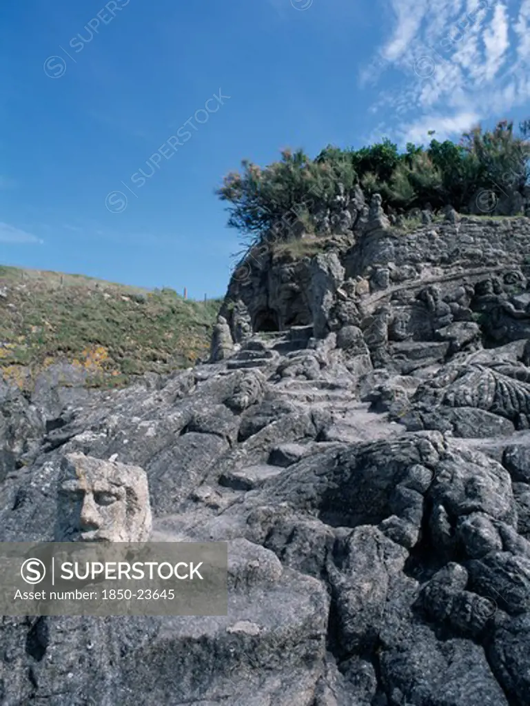 France, Brittany, St Malo, Rochers Sculptes De Rotheneuf. Sculptures Of Faces Carved Into Rock