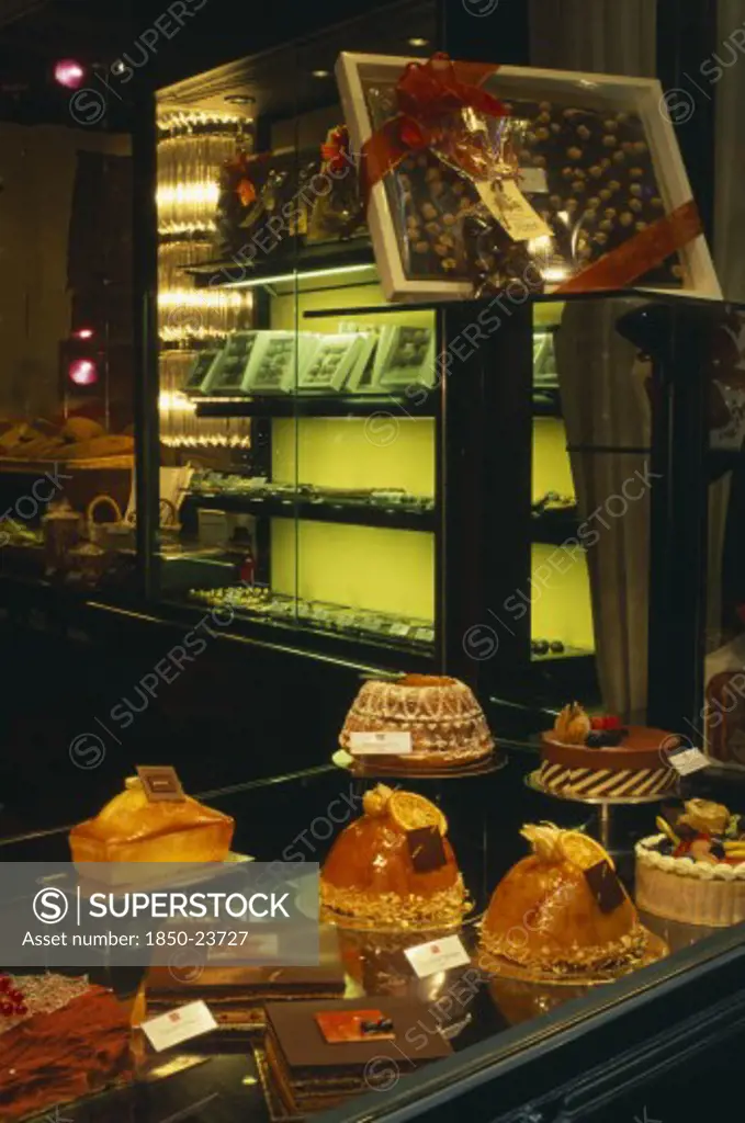 Switzerland, Ticino, Lugano, Cakes And Chocolate Displayed In Window Of Cafe.