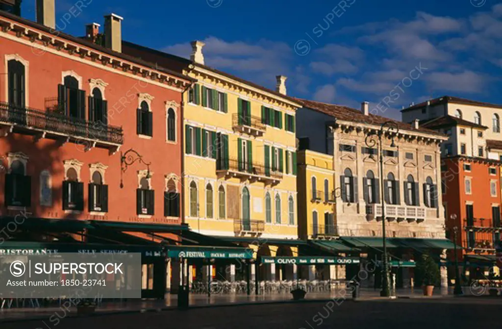 Italy, Veneto, Verona, Piazza Bra.  Line Of Empty Bars And Cafes And Painted Facades Of Architecture Overlooking Square.