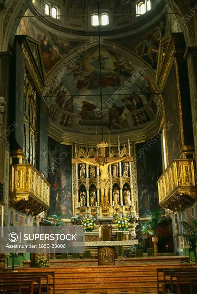 Italy, Lombardy, Lake Garda, 'Salo.  Interior Of The Duomo With Ornate Golden Altarpiece, Crucifix And Painted Walls And Vaulted Ceiling.'