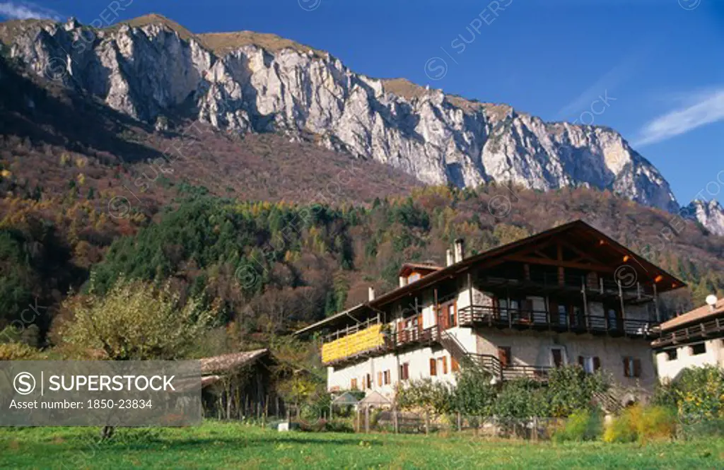 Italy, Trentino-Alto Adige, Lake Garda Area, 'Alpine Farmstead Near Lago Di Tenno.  Traditional Building With Over Hanging Roof And Balcony, Outbuildings And Mountain Backdrop.'