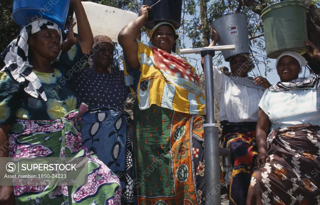 Tanzania, Shinyanga, Women At Standpipe Carrying Pails Of Clean Water On Their Heads.  Following 1994 Cholera Outbreak An Urban Health Programme Was Set Up To Teach Health Awareness.