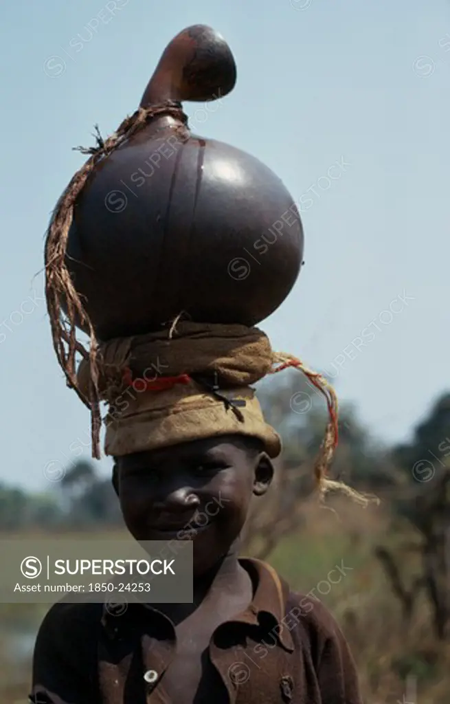 Burundi, Children, Portrait Of Hutu Child Carrying Water Pot On Head.
