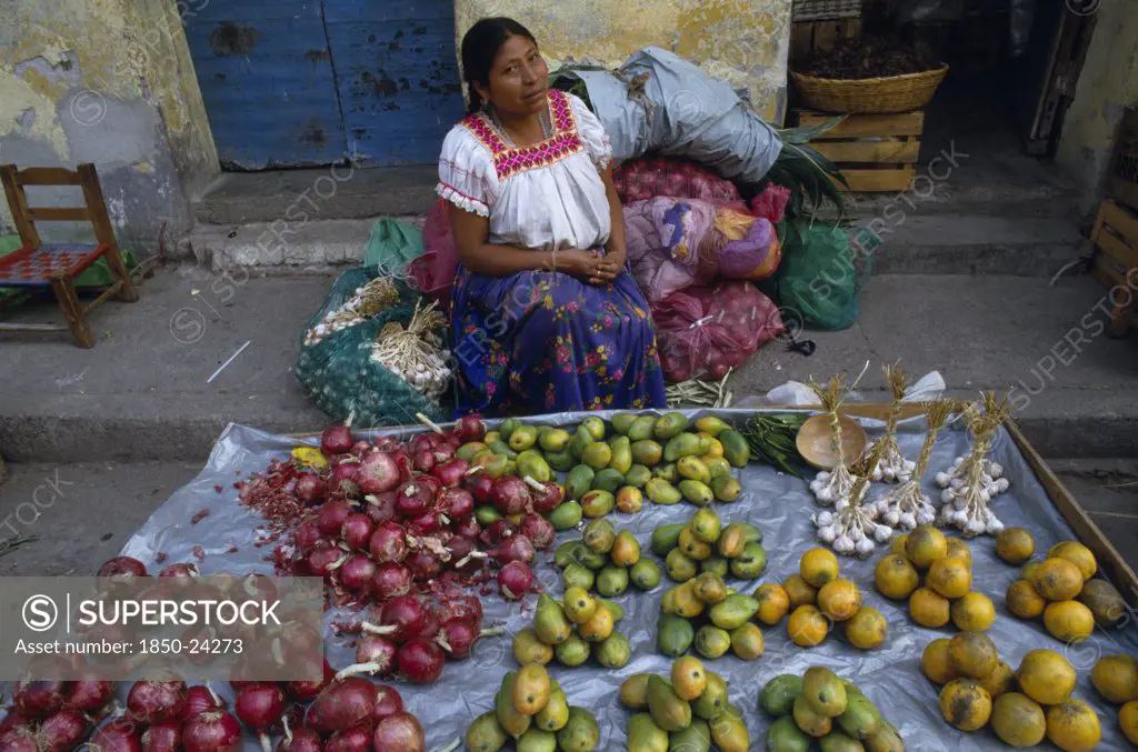 Mexico, Guerrero, Markets, 'Woman Sitting Behind Street Stall Display Selling Onions, Garlic And Fruit.'