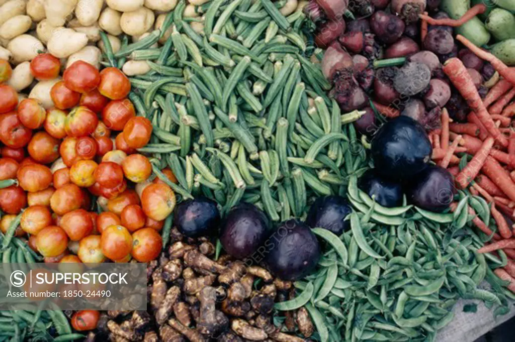 India, Madhya Pradesh, Gwalior, 'Close Cropped View Of Vegetables Displayed On Market Stall Including Okra, Aubergines, Tomatoes, Beetroot, Potatoes And Carrots.'