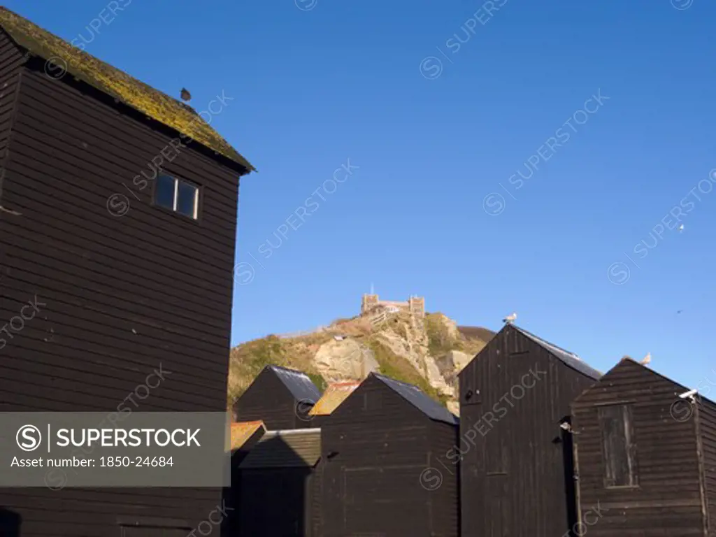 England, East Sussex, Hastings, Black Wooden Huts Used For Storing Fishing Nets.The East Hill Lift Funicular Railway Behind.