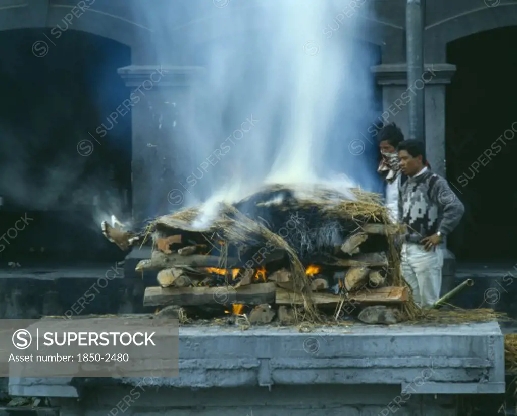 Nepal, Kathmandu, Cremation Ceremony.  Funeral Pyre And Burning Body.