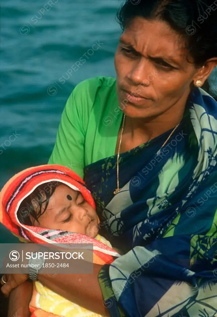 Sri Lanka, People, Woman Holding Baby In Her Arms. Traditionally Dressed And Wearing Modern Wrist Watch