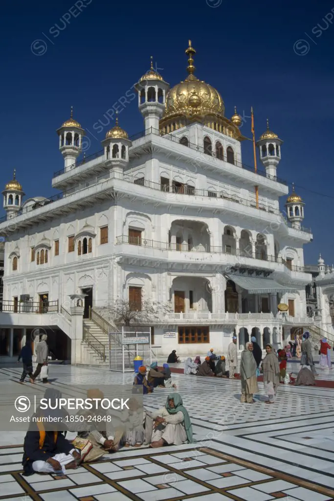 India, Punjab, Amritsar, The Sri Akal Takhat Sahib Sikh Parliment Building In The Golden Temple With Groups Of People Gathered Outside