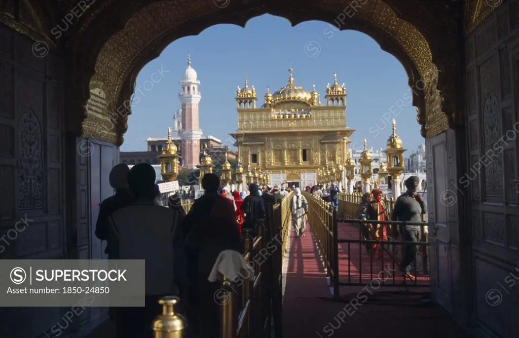 India, Punjab, Amritsar, Entrance Arch To The Golden Temple With People Walking Along Red Carpet