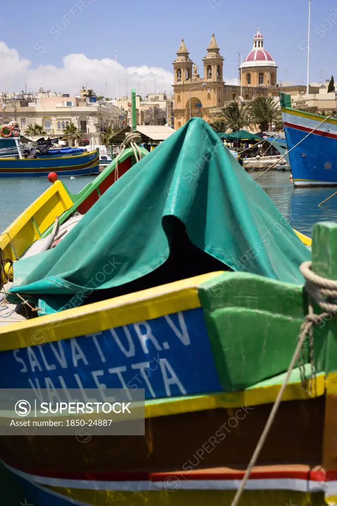 Malta, Marsaxlokk , Fishing Village Harbour On The South Coast With Colourful Kajjiki Fishing Boats And The Church Dedicated To Our Lady Of The Rosary The Madonna Of Pompeii