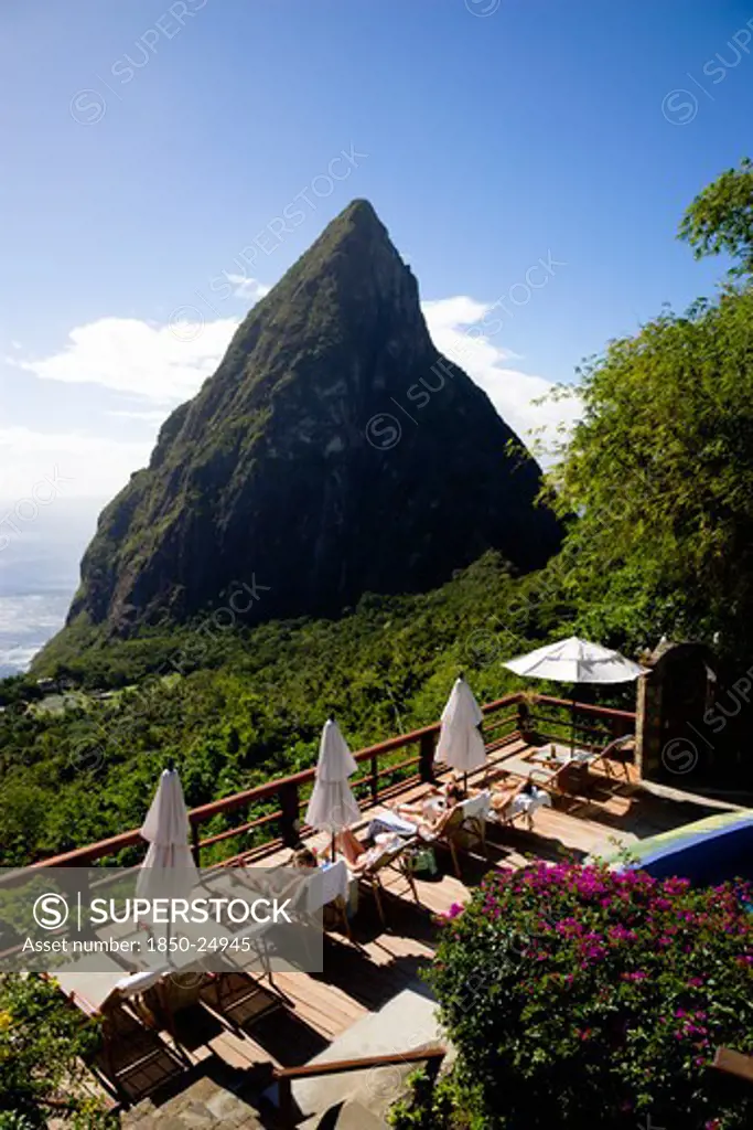 West Indies, St Lucia, Soufriere , Val Des Pitons Tourists Sunbathing On The Sun Deck Beside The Pool At Ladera Spa Resort Hotel Overlooking Petit Piton Volcanic Plug And Jalousie Beach