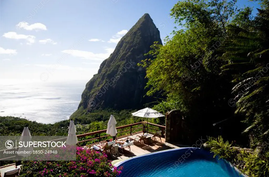 West Indies, St Lucia, Soufriere , Val Des Pitons Tourists Sunbathing On The Sun Deck Beside The Pool At Ladera Spa Resort Hotel Overlooking Petit Piton Volcanic Plug And Jalousie Beach