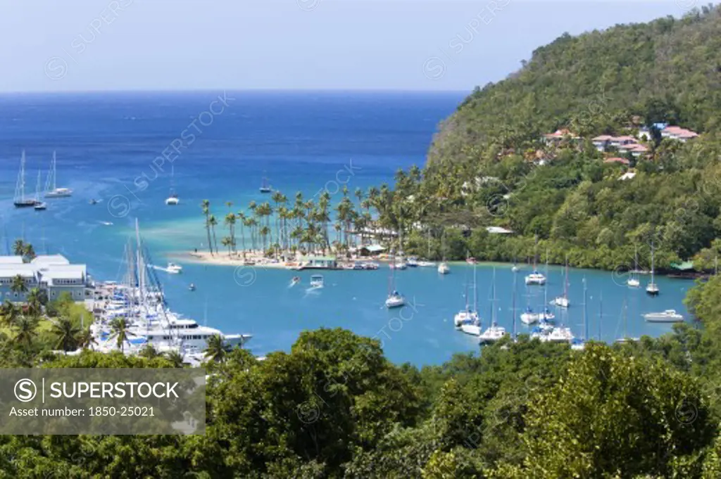 West Indies, St Lucia, Castries , Marigot Bay The Harbour With Yachts At Anchor The And Lush Surrounding Valley. The Small Coconut Palm Tree Lined Beach Of The Marigot Beach Club Sits At The Entrance To The Harbour
