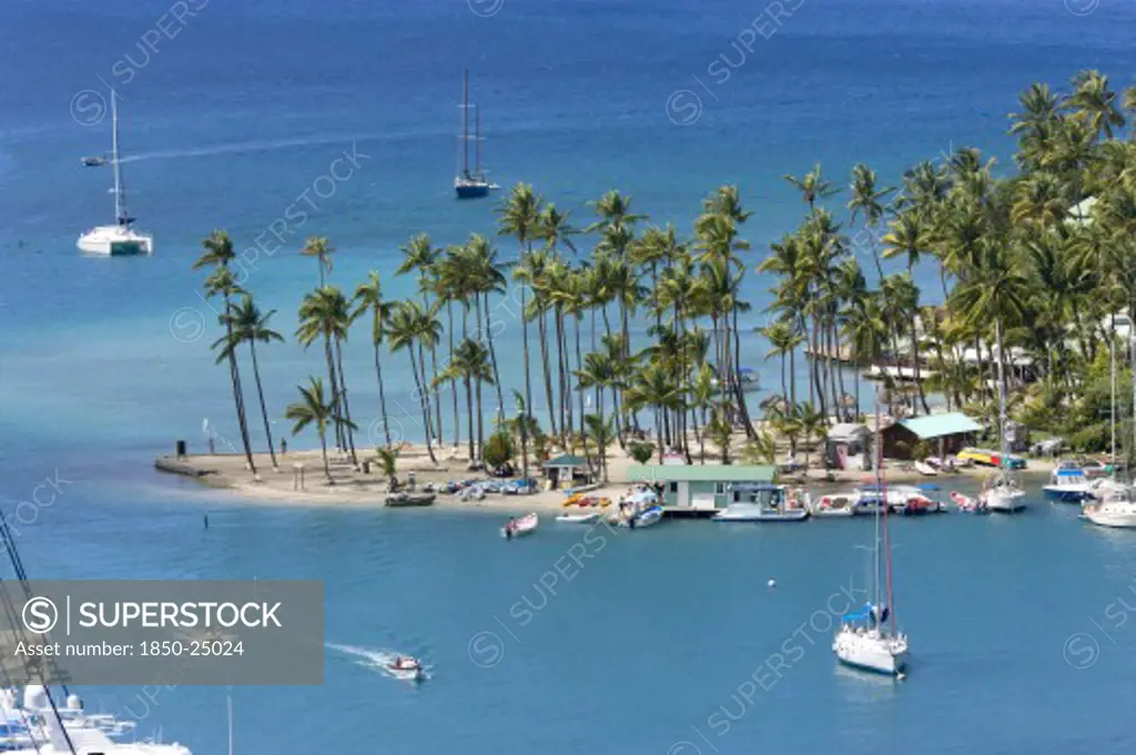 West Indies, St Lucia, Castries , Marigot Bay Yachts At Anchor Beyond The Small Coconut Palm Tree Lined Beach Of The Marigot Beach Club Sitting At The Entrance