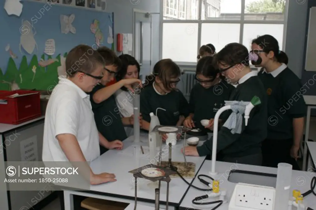 Children, Education, Secondary, Food Technology Science Pupils Carrying Out An Experiment To Measure The Evaporation Of A Salt Solution Using A Bunsen Burner.
