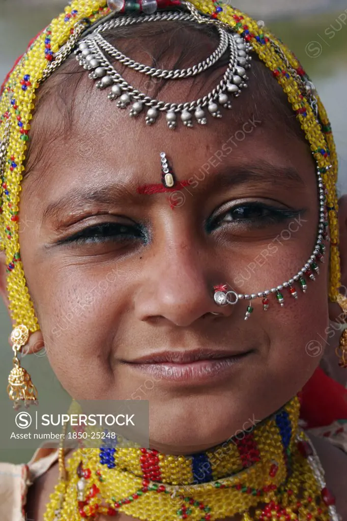 India, Rajasthan, Jodhpur, Portrait Of A Young Indian Girl At Meherangarh Fort Wearing Nose Ring And Chain And Traditional Bead Jewelery And Black Kohl Eyeliner.