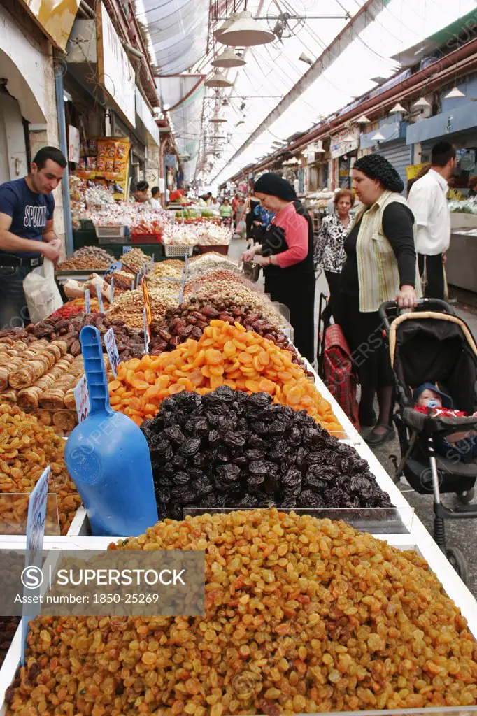 Israel, Jerusalem, 'Women With Baby In Pram Making Purchase At Stall Selling Dried Fruit And Nuts Including Sultanas, Apricots And Peanuts In Covered Main Food Market Of Jerusalem'