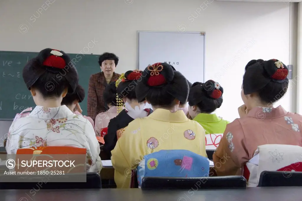 Japan, Honshu, Kyoto, 'Gion Area, The Neighbourhood Where Geisha Live, Study And Perform.  Maiko Apprentice Geisha Attending A Class At Mia Garatso School Of Geisha, Seated With Backs To Camera Looking Towards Female Teacher.'
