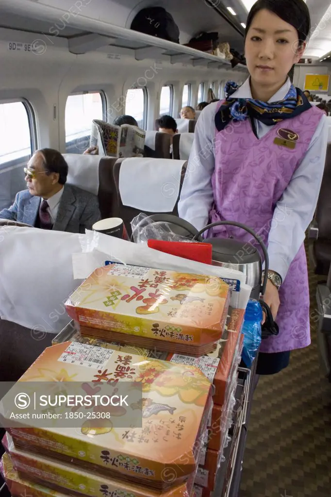 Japan, Honshu, 'Shinkansen Train Series 700, The Bullet Train Travelling Between Tokyo And Kyoto.  Train Hostess Serving Bento Lunchboxes And Refreshments From Trolley. '