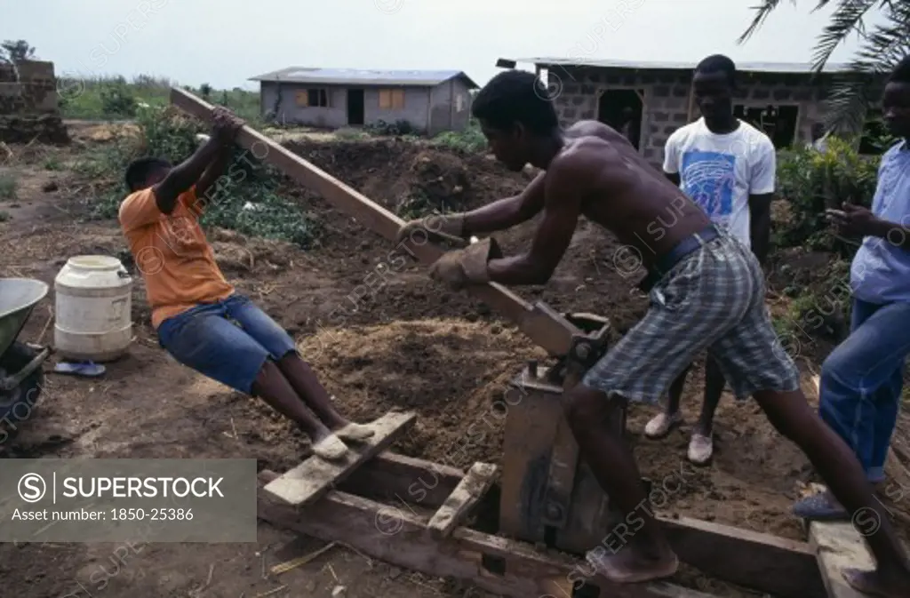 Ghana, Buduburam, Using Hand Operated Machine Worked By The Action Of A Lever To Make Bricks.