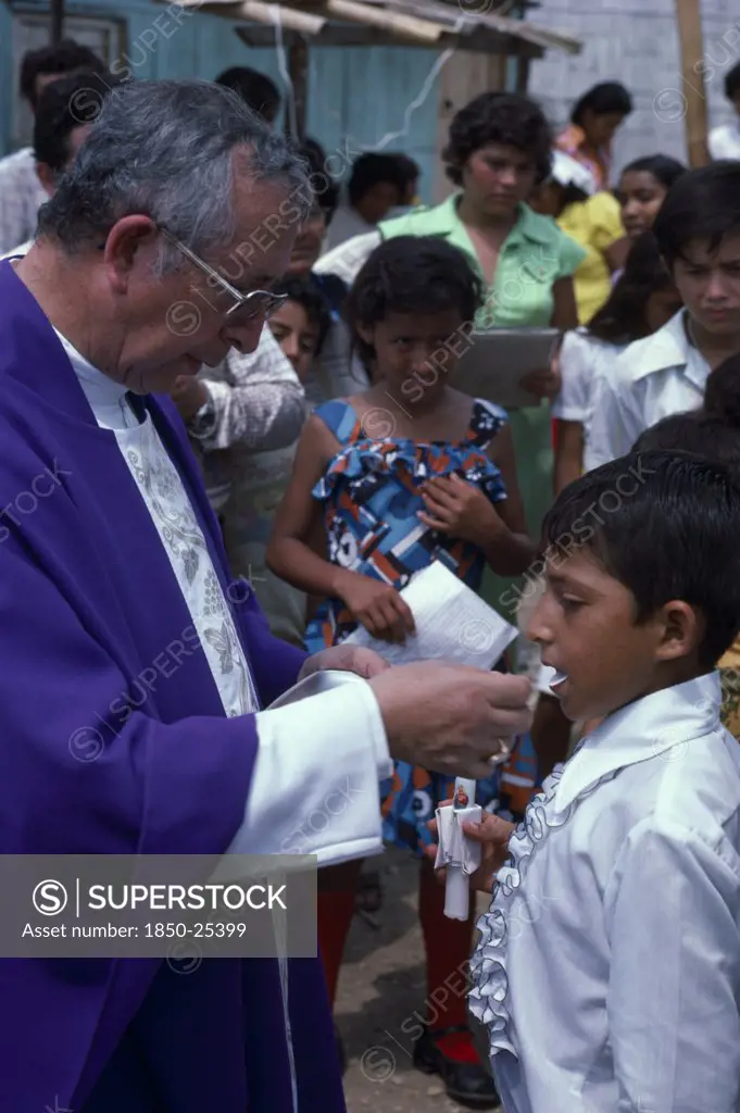 Ecuador, Guayas Province, Guayaquil , Roman Catholic Bishop Giving Communion In Barrio Indio Guayas Slum Neighbourhood.