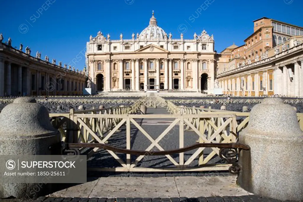 Italy, Lazio, Rome, Vatican City The Basilica Of St Peter With Tourists At The Entrance And Empty Seating For The Papal Audience In The Piazza San Pietro