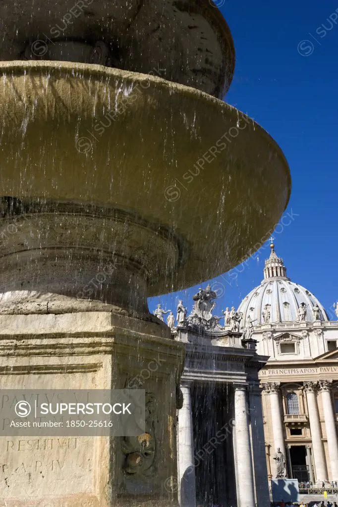 Italy, Lazio, Rome, Vatican City The Basilica Of St Peter And The Square Or Piazza San Pietro With Tourists And A Water Fountain In The Foreground
