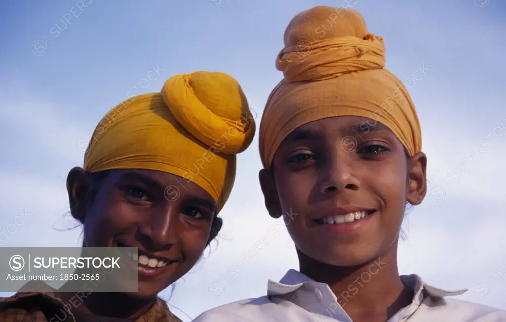 India, Punjab, Amritsar, 'Two Sikh Boys.  Head And Shoulders Portrait, Smiling.'