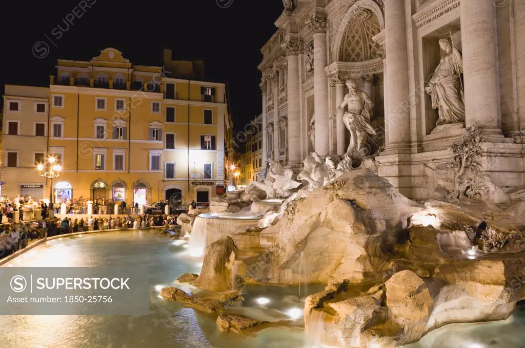 Italy, Lazio, Rome, The 1762 Trevi Fountain By Nicola Salvi Illuminated At Night With Tourists In The Piazza Di Trevi With Tourists In The Piazza Di Trevi