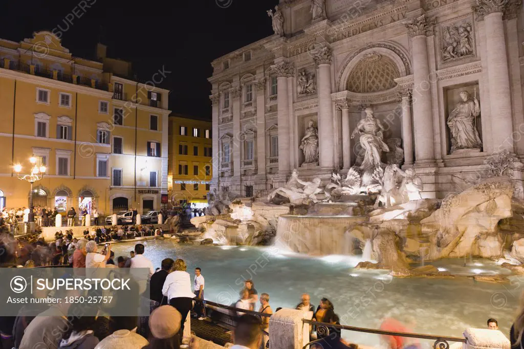 Italy, Lazio, Rome, The 1762 Trevi Fountain By Nicola Salvi Illuminated At Night With Tourists In The Piazza Di Trevi