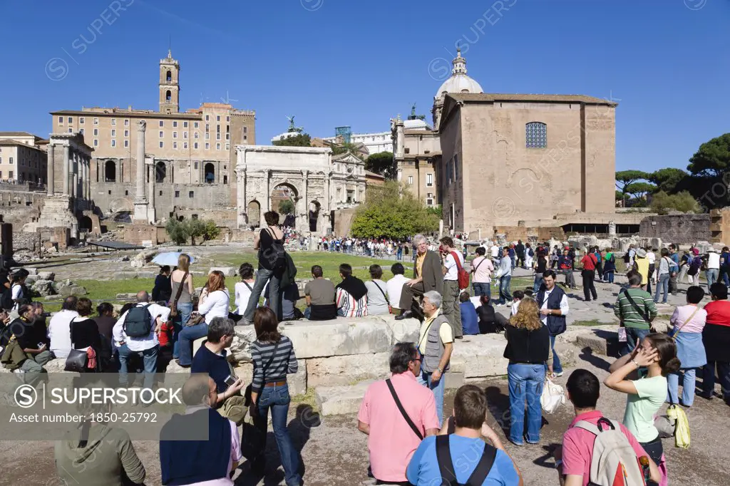 Italy, Lazio, Rome, 'The Forum And Tourists With From Left To Right The Columns Of The Temple Of Saturn, The Palazzo Senatorio, The Triumphal Arch Of Septimius Severus And The Curia'