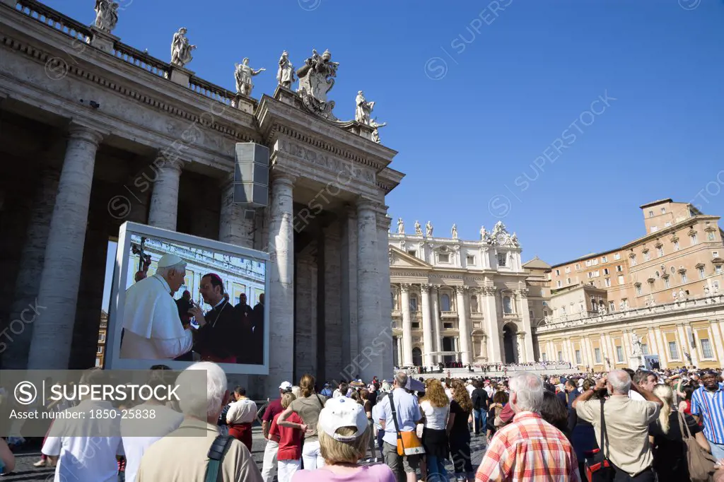 Italy, Lazio, Rome, Vatican City Pilgrims In St Peter'S Square For The Wednesday Papal Audience In Front Of The Basilica Watching Pope Benedict Xvi Joseph Alois Radzinger With A Cardinal On A Large Video Tv Monitor Display