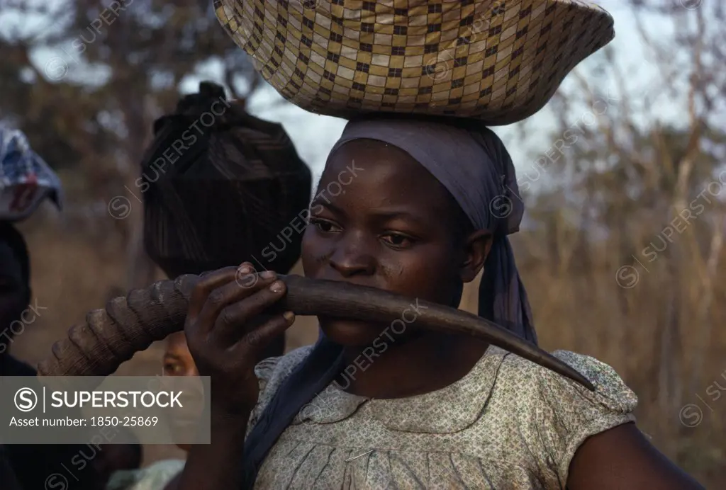 Malawi, Tribal People, Yau Tribe, Yau Woman Blowing A Water Buck Horn While Carrying A Load On Her Head Standing In The Fields