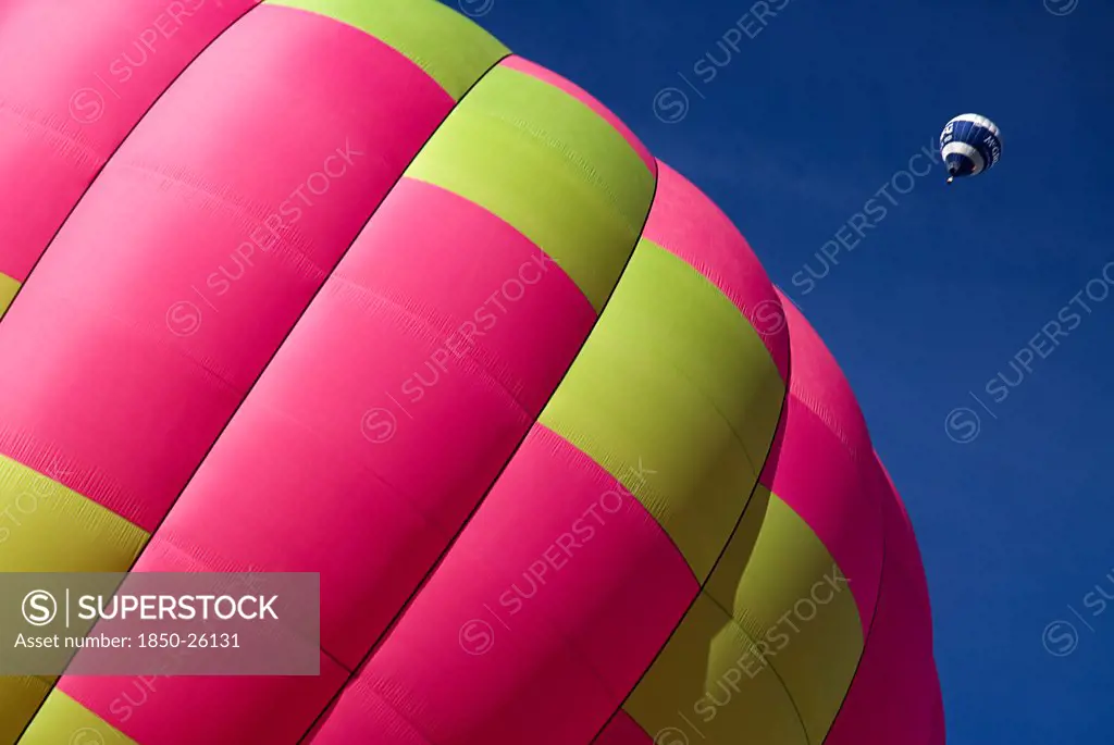 Switzerland, Canton De Vaud, Chateau D'Oex, Section Of Hot Air Balloon On Ground As Another Balloon Ascends