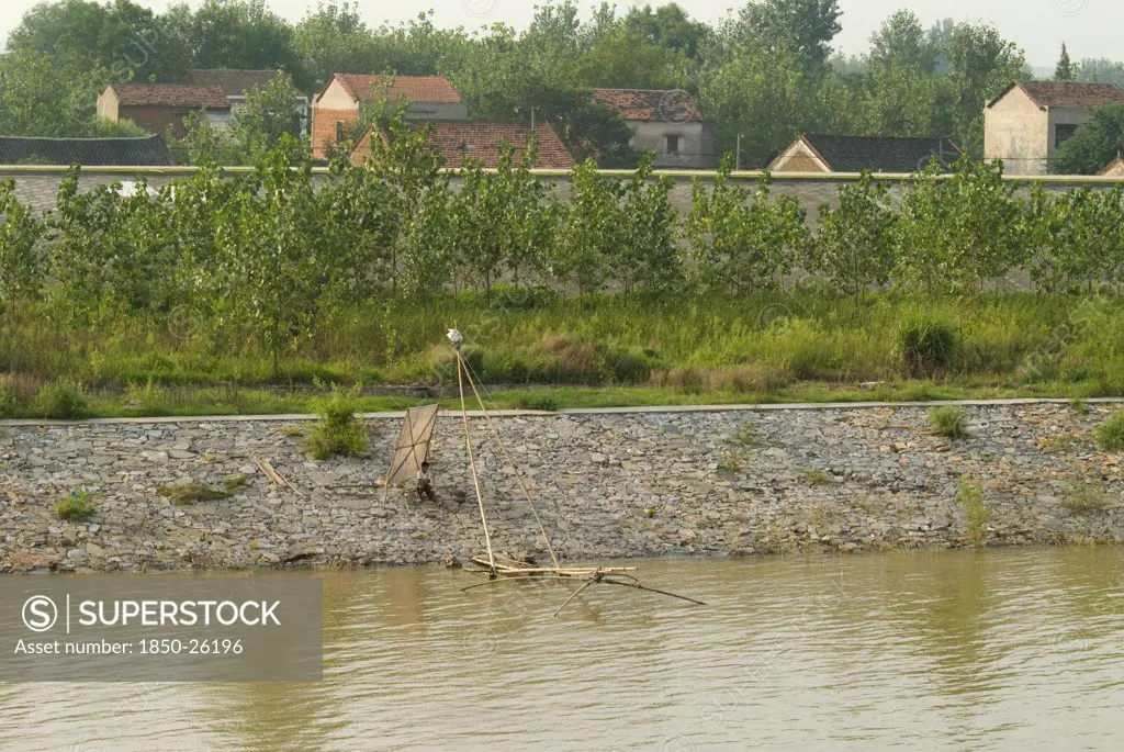 China, Hubei, Yangtze, A Man Fishing On The Lower Embankment. Two Lined Embankments Protect This Village East Of Wuhan From Annual Flooding Of The Yangtze River