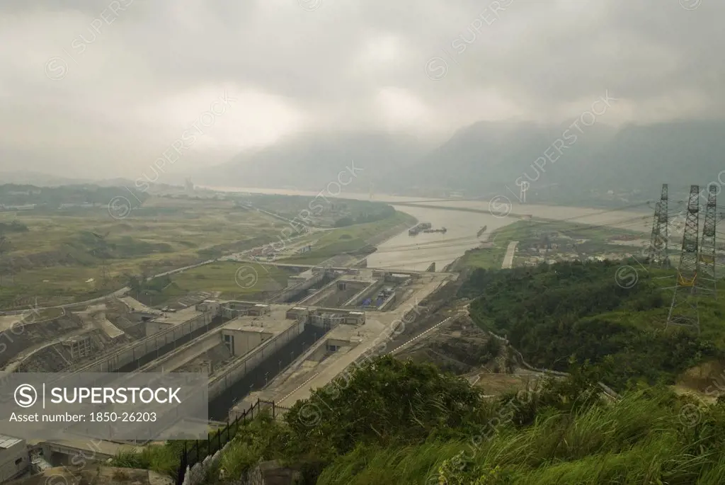 China, Hubei , Sandouping, Hydro-Electric Pylons And The East Bound Locks At The Three Gorges Dam Project On The Yangtze River At Sandouping. Power Generation Increased River Trade And Flood Control Are The Main Objectives Of The Project Due For Completion In 2009