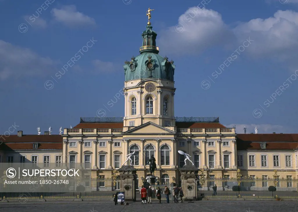 Germany, Berlin, Charlottenburg Palace.  Exterior Facade Of Eighteenth Century Baroque Palace With Visitors Outside Ironwork Gates.