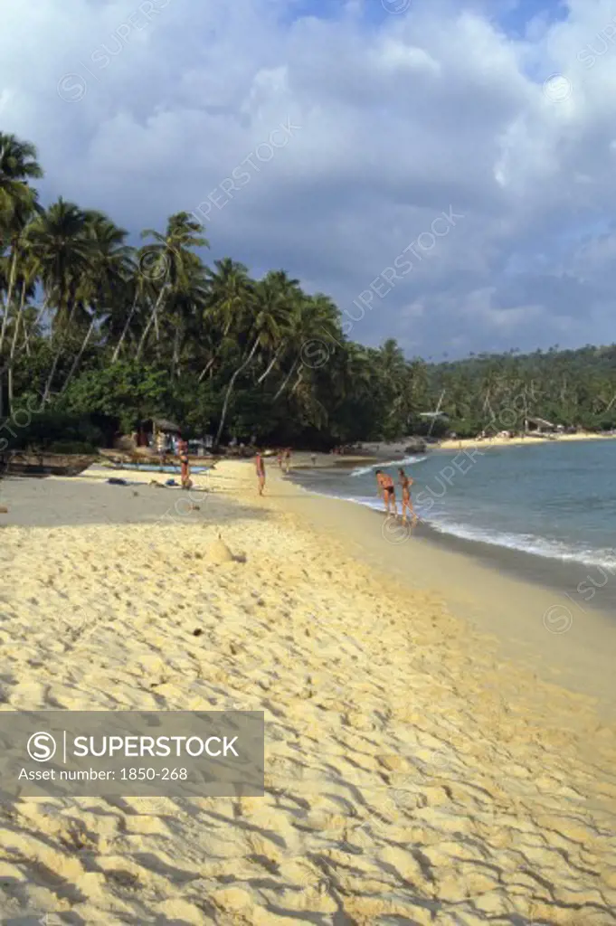 Sri Lanka, Unawatuna, View Along Golden Sandy Beach Lined With Palms And Bathers By Boats Pulled On To The Sand