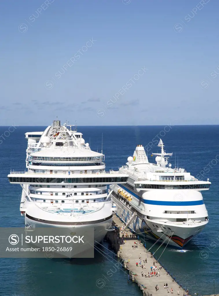 West Indies, Grenada, St George, Two Cruise Ships The Caribbean Princess And Aida Aura Moored At The Cruise Ship Terminal In The Capital City Of St George'S With Passengers Walking Along The Jetty Between The Liners