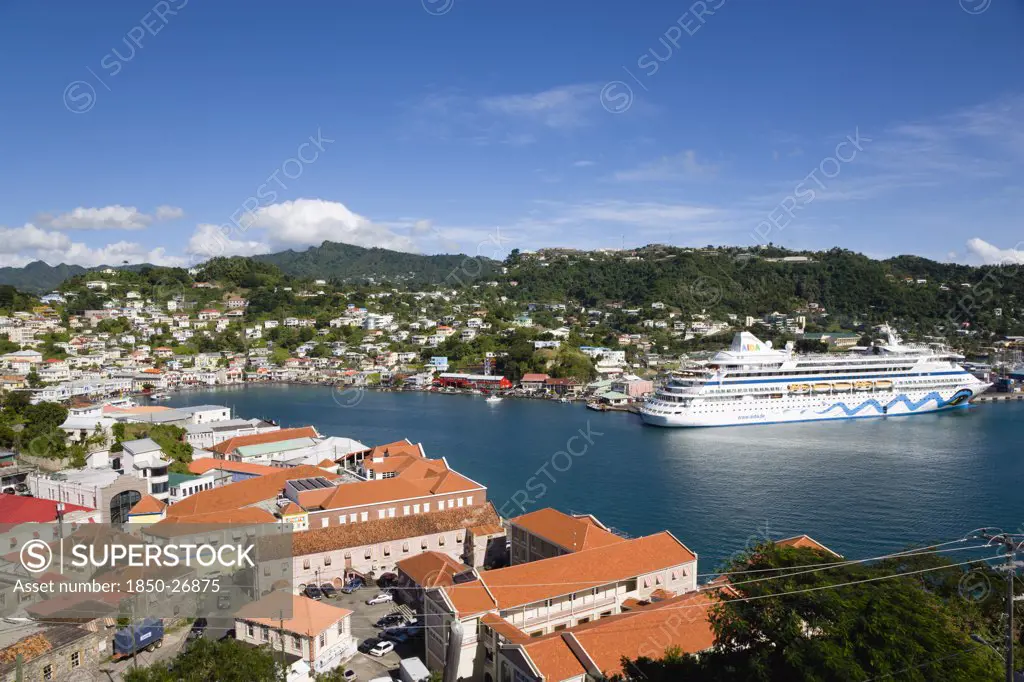 West Indies, Grenada, St George, The Carenage Harbour Of The Capital City Of St George'S Surrounded By Hills Lined With Houses And Other Buildings And The Cruise Ship Aida Aura Moored At The Docks