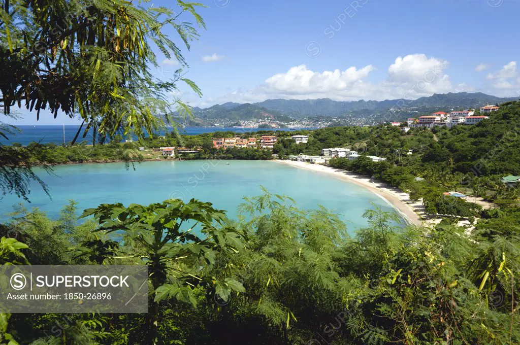 West Indies, Grenada, St George, The Aquamarine Sea And Tree Lined White Sand Of Bbc Beach In Morne Rouge Bay With The Capital City Of St George'S In The Distance