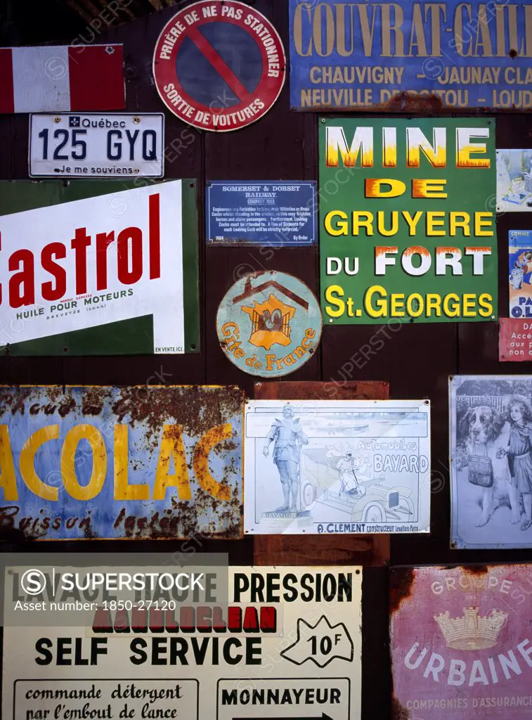 France, Indre Et Loire, Chinon, A Collection Of Enamelled Advertising Signs Seen On A Garage Door. Small Blue And White Sign Which Refers To Somerset And Dorset Railway.