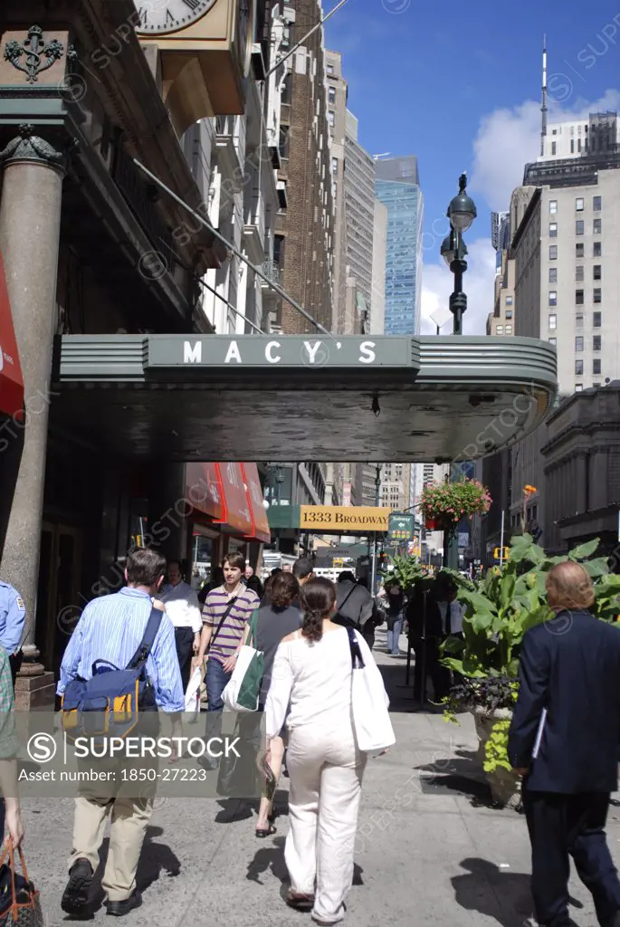 Usa, New York, Manhattan, Broadway With People Walking Along The Sidewalk Outside The Entrance To Macy'S Department Store.