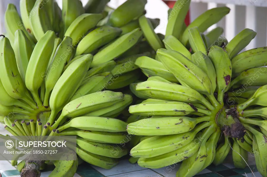 West Indies, Grenada, Carriacou, Hillsborough Bundles Of Green Bananas On A Stall In The Main Street.