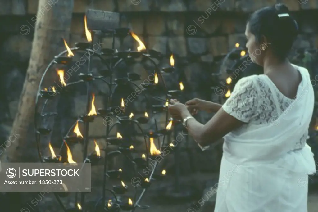 Sri Lanka, Anuradhapura, Lighting Lamp Beside Bo Tree During Wesak Festival.