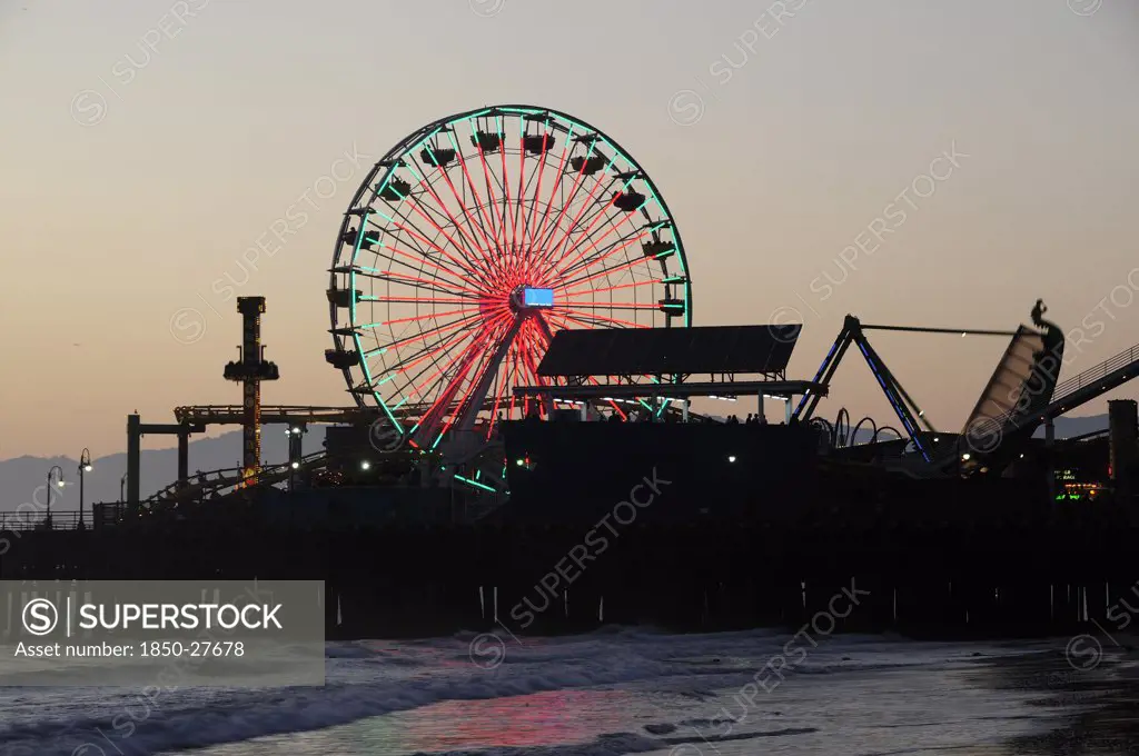 Usa, California, Los Angeles, Santa Monica Pier Silhouetted At Dusk. Ferris Wheel Funfair